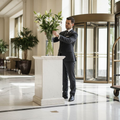 Concierge arranging lilies in marble hotel foyer